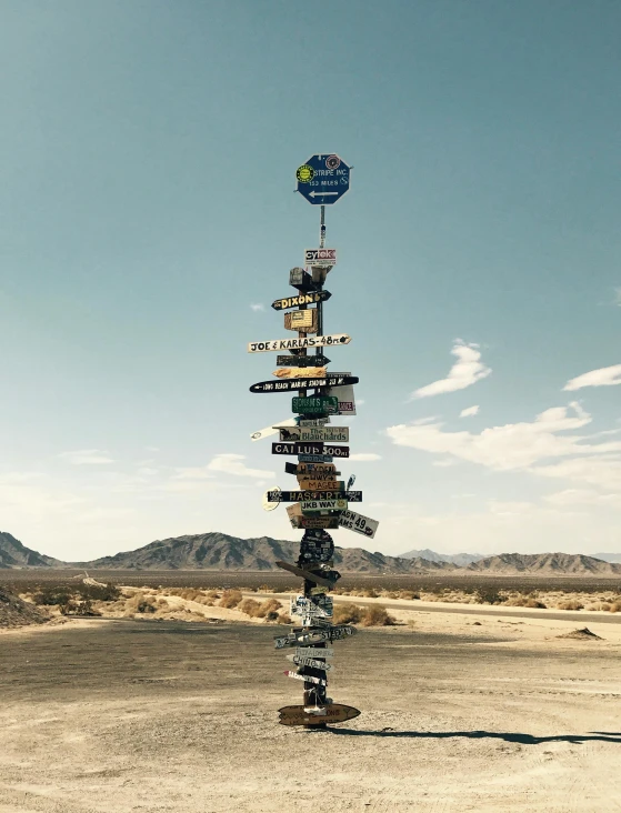 a sign post in the middle of a desert, by Jessie Algie, kinetic art, stacked image, travel guide, lots of signs, where the planets are candy