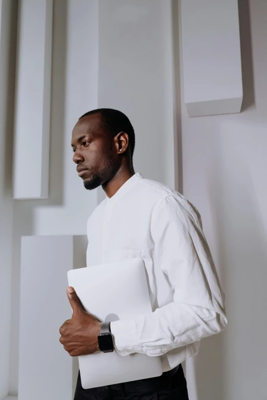 a man in a white shirt and black pants, inspired by Theo Constanté, pexels contest winner, afrofuturism, holding notebook, elegant profile posing, receding hairline, adut akech