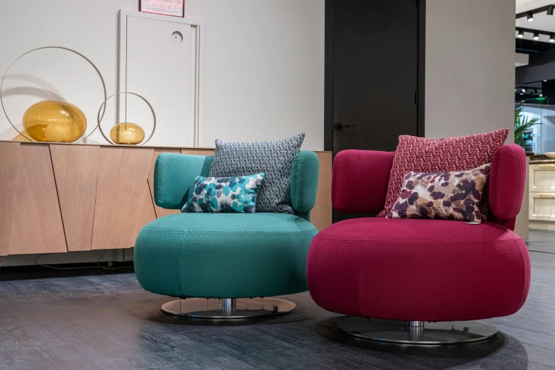 a couple of colorful chairs sitting next to each other, teal silver red, bloomy, in house, lounge