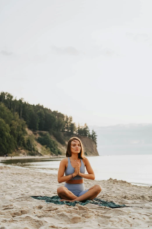 a woman is doing yoga on the beach, a portrait, by Anna Haifisch, unsplash, washington state, 😭 🤮 💕 🎀, sitting pose, anna nikonova aka newmilky