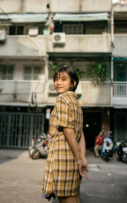 a woman standing in the middle of a street, inspired by Ruth Jên, pexels contest winner, wearing a plaid shirt, young cute wan asian face, square, high quality photo