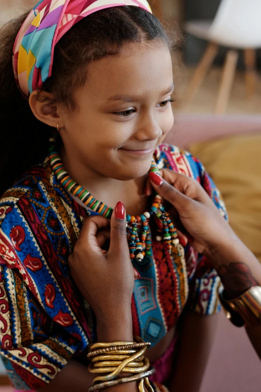 a woman helping a young girl fix her tie, trending on unsplash, process art, wearing an african dress, wooden jewerly, thumbnail, multicolored