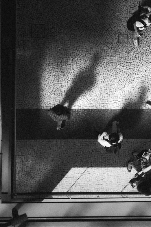 a black and white photo of a group of people, inspired by Sergio Larraín, conceptual art, light from above, in sao paulo, ( ( photograph ) ), deep shadows and colors