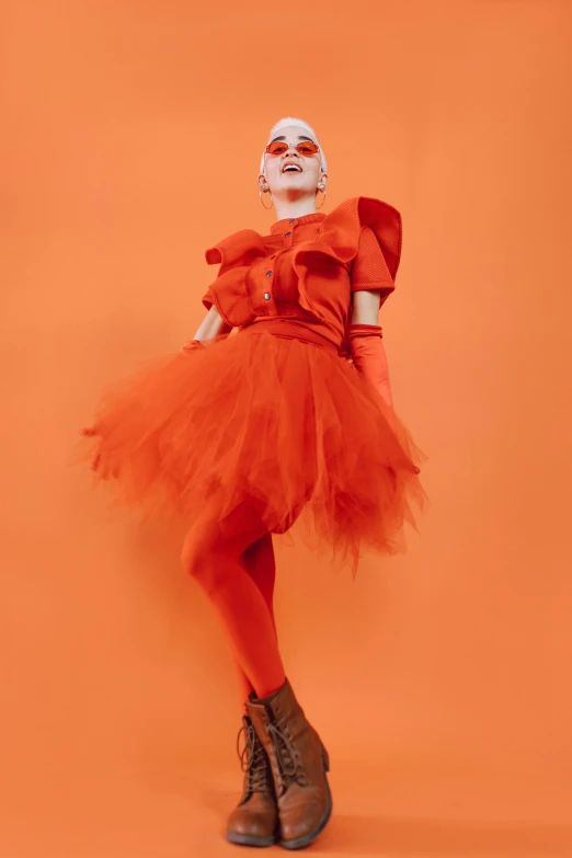 a woman in a red dress posing for a picture, an album cover, inspired by Bert Stern, pexels, fuzzy orange puppet, an epic non - binary model, modern stylish glamour tutu, comme des garcon campaign