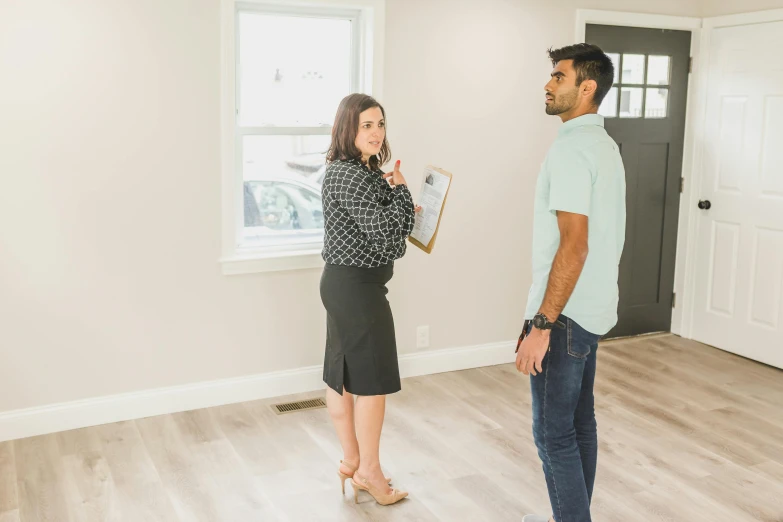 a man and a woman standing in a room, listing image, people looking at a house, professional photo, full body image