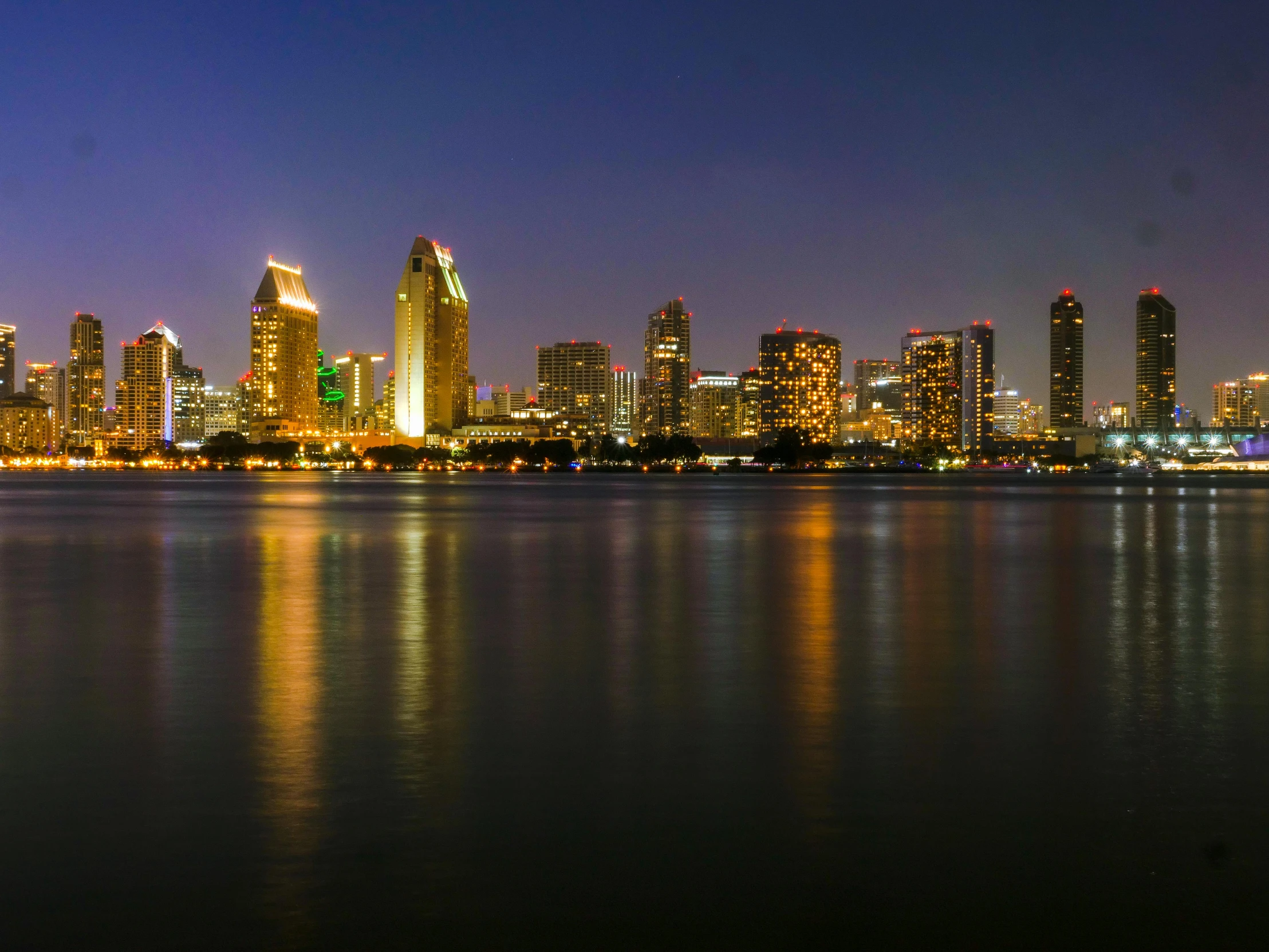 a large body of water with a city in the background, by Tom Wänerstrand, pexels contest winner, martin sandiego, panoramic, late night, slide show