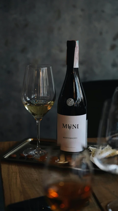 a bottle of wine sitting on top of a wooden table, pexels contest winner, mingei, morandi colour scheme, label, mini, mamou - mani