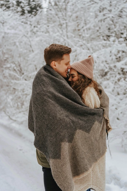 a man and woman wrapped in a blanket in the snow, pexels contest winner, two men hugging, attractive girl, video, 2019 trending photo