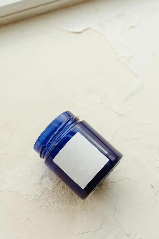 a blue jar of cream on a white surface, inspired by Yves Klein, unsplash, product view, petite, homemade, top