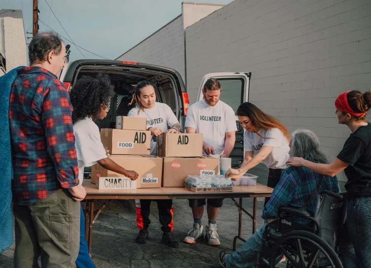 a group of people standing around a table with boxes on it, first aid kit, sza, hunger, 2 0 2 2 photo