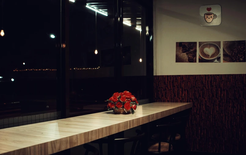 a table with a vase of flowers on top of it, inspired by Elsa Bleda, unsplash, fantastic realism, futuristic pizza hut at night, caulfield, panoramic shot, dark warm light