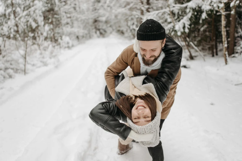 a man carrying a little girl in the snow, pexels contest winner, avatar image, playful pose, leather clothing, thumbnail