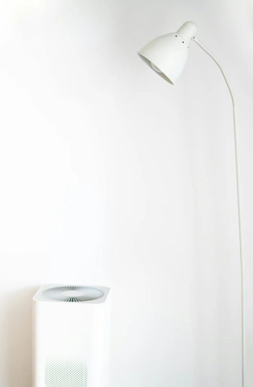 a white lamp sitting on top of a wooden table, by Will Ellis, minimalism, an upside down urinal, samsung smartthings, dwell, white wall