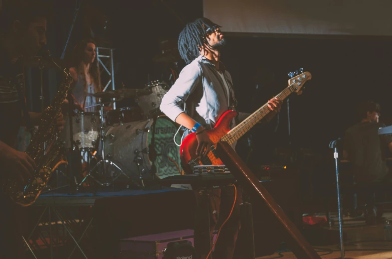 a man that is standing up with a guitar, pexels contest winner, antipodeans, band playing, afro-psychedelia, vaughan bass, on a stage