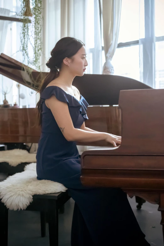 a woman in a blue dress sitting at a piano, inspired by Zheng Xie, unsplash, sitting on top a table, in house, performing, profile image