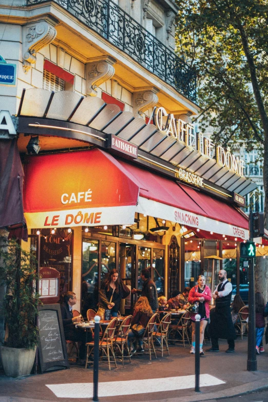 a group of people walking down a street in front of a cafe, the city of paris, a red cape, awnings, promo image