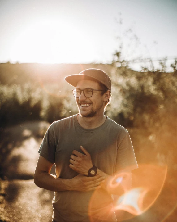 a man standing in the middle of a dirt road, cute slightly nerdy smile, ((sunset)), highly upvoted, lgbtq