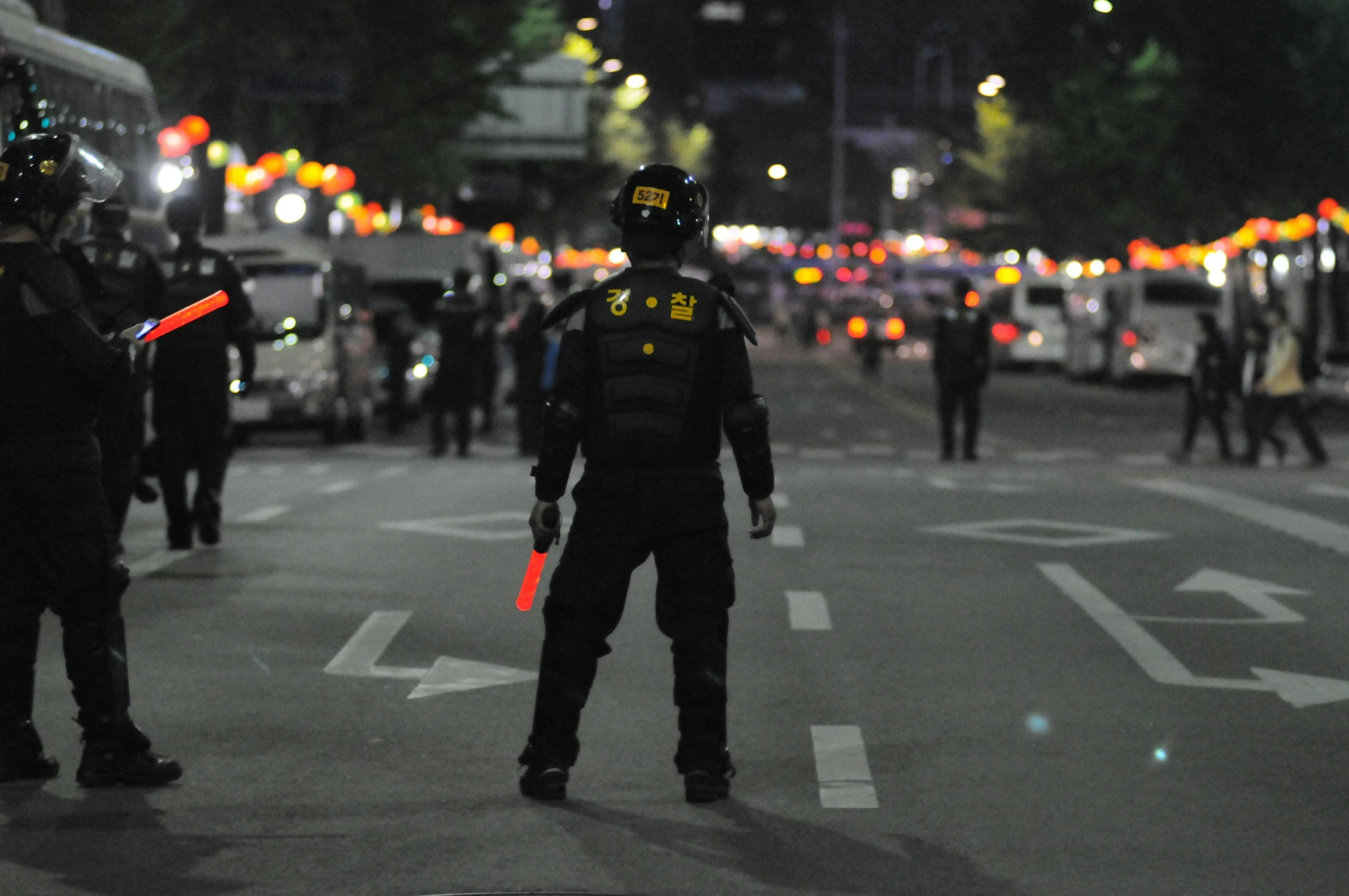 a police officer standing in the middle of a street, by Alejandro Obregón, reddit, after a riot, neon samurai, photograph credit: ap, ballard