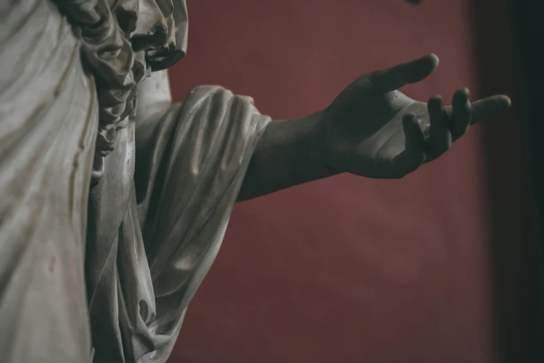 a close up of a statue of a person, a statue, by Alessandro Allori, pexels contest winner, classical realism, middle finger, on a red background, wearing a grey robe, hands reaching for her