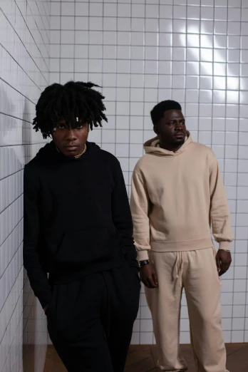 two men standing next to each other in a bathroom, an album cover, by Nyuju Stumpy Brown, trending on unsplash, renaissance, beige hoodie, wearing a track suit, profile image, white and black clothing