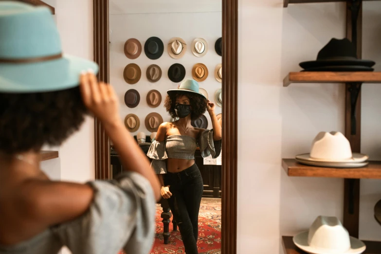 a woman taking a picture of herself in a mirror, by Carey Morris, trending on pexels, hats, exiting store, wearing a mask, dark skinned