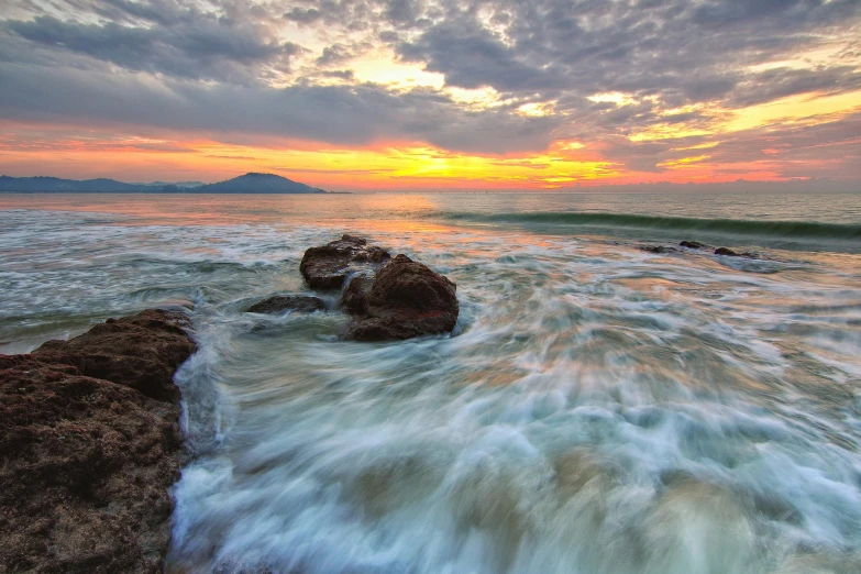 a sunset over the ocean with rocks in the foreground, unsplash contest winner, water swirling, pastel overflow, mount, seaview