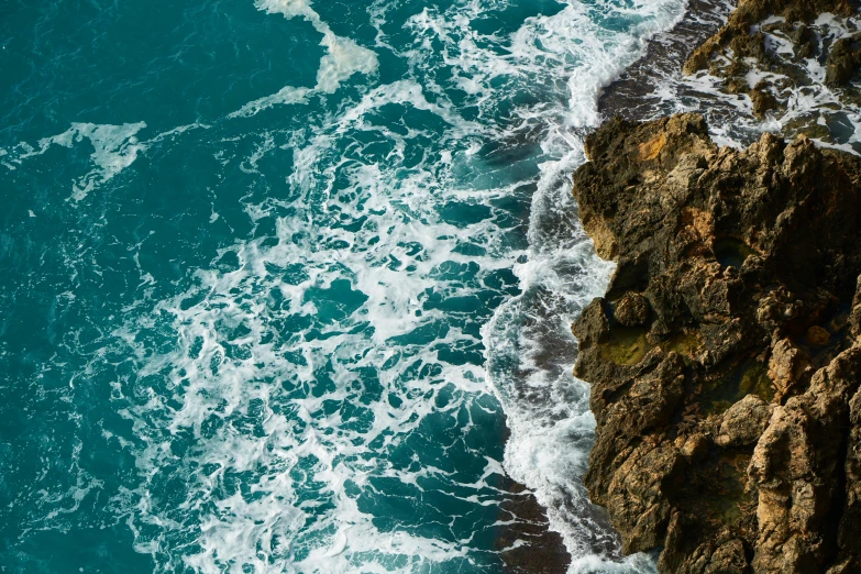 a man standing on top of a cliff next to the ocean, pexels contest winner, renaissance, extremely detailed water texture, teal white gold color palette, currents, spiraling