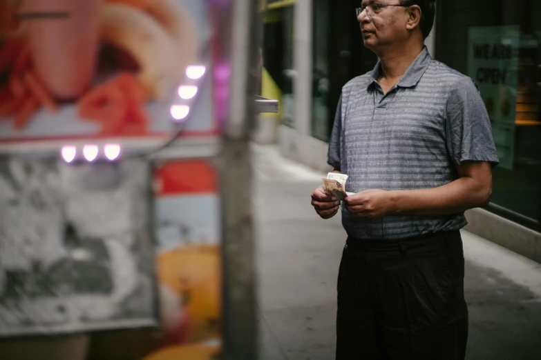 a man standing on a sidewalk holding a cup of coffee, a picture, pexels contest winner, 8 0 s asian neon movie still, food stall, humans of new york, 15081959 21121991 01012000 4k