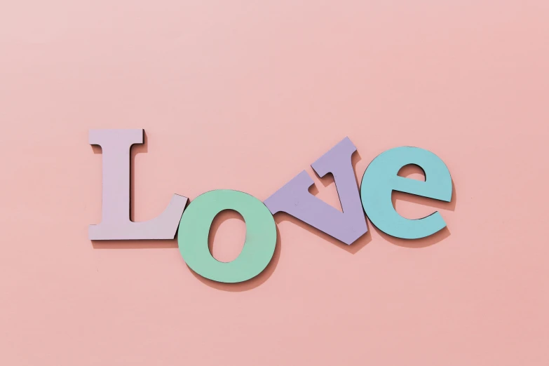 the word love on a pink background, inspired by Peter Alexander Hay, trending on pexels, letterism, mauve and cyan, eva elfie, wooden art toys, wall art