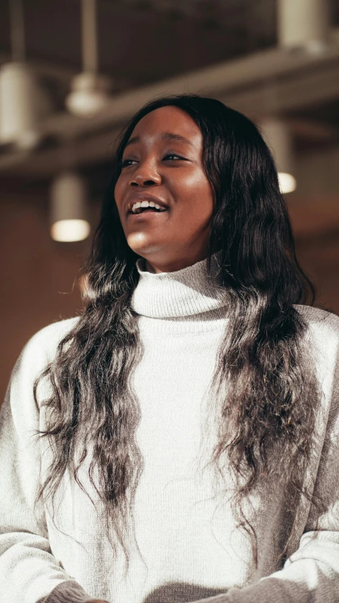 a woman with long hair standing in a room, trending on unsplash, hurufiyya, large black smile, wearing turtleneck, ( ( dark skin ) ), shiny silver