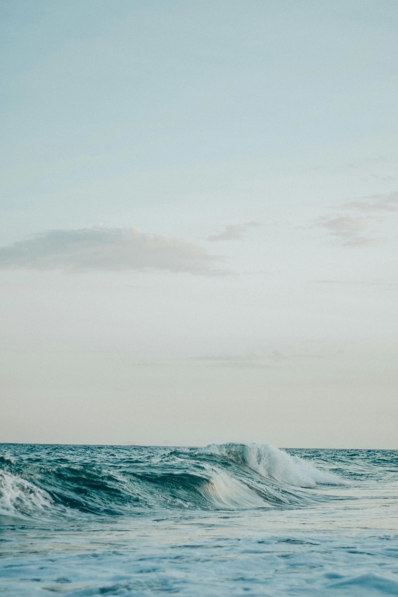 a man riding a surfboard on top of a wave in the ocean, unsplash, minimalism, sky, 4 k film still, early evening, ignant