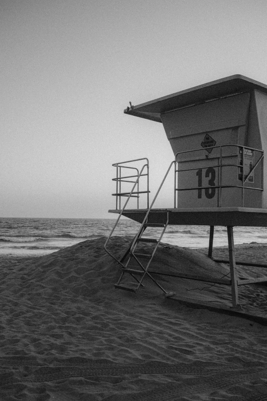 a lifeguard tower sitting on top of a sandy beach, a black and white photo, los angeles 2 0 1 5, ffffound, early morning mood, street photo