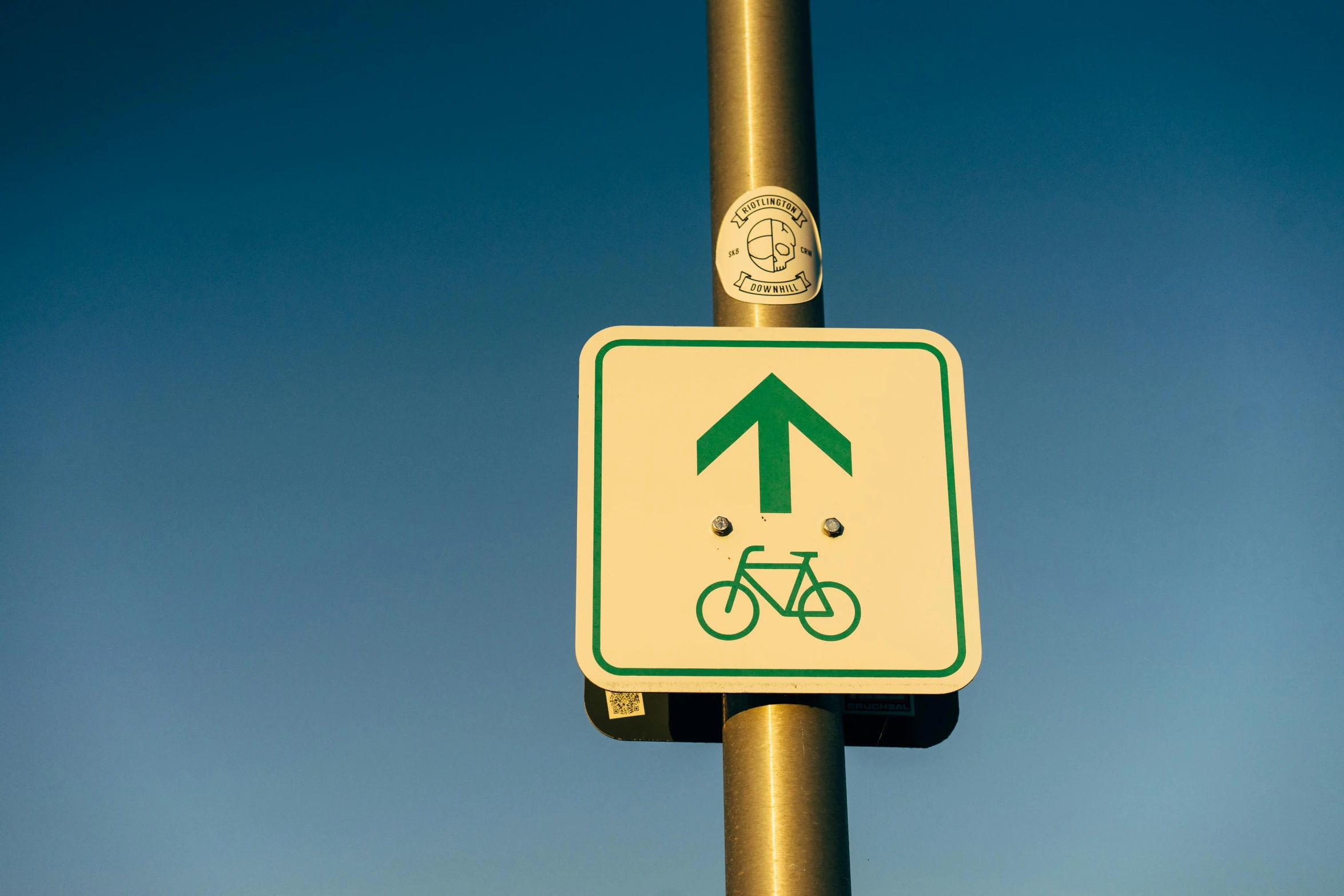 a close up of a street sign on a pole, a poster, by Julia Pishtar, unsplash, happening, riding a bike, pictogram, wide greenways, leading to the sky