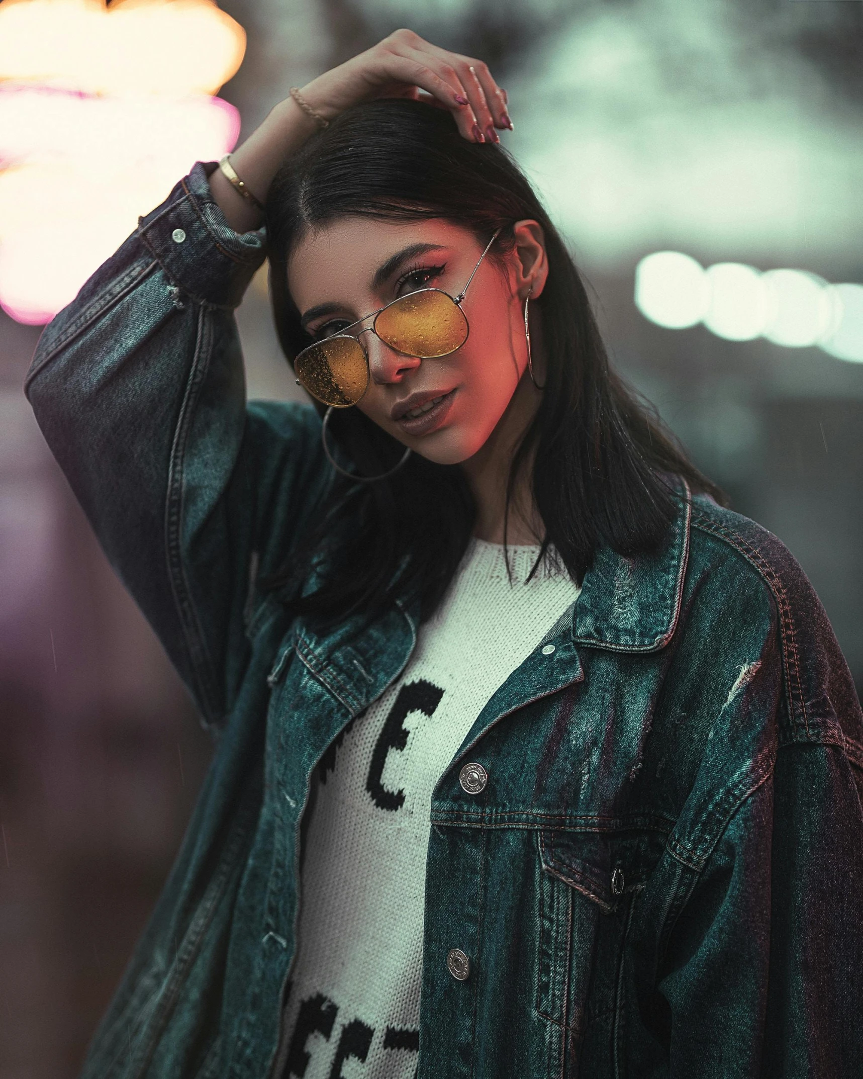 a woman wearing sunglasses and a denim jacket, a colorized photo, trending on pexels, yellow lights, trending on r/streetwear, bisexual lighting, wearing beautiful clothes