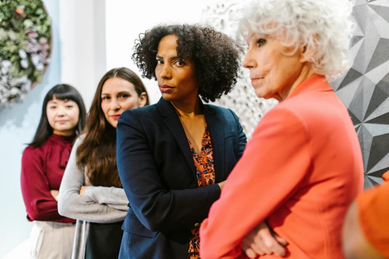 a group of women standing next to each other, focused stare, best practice, foreground, 2 people