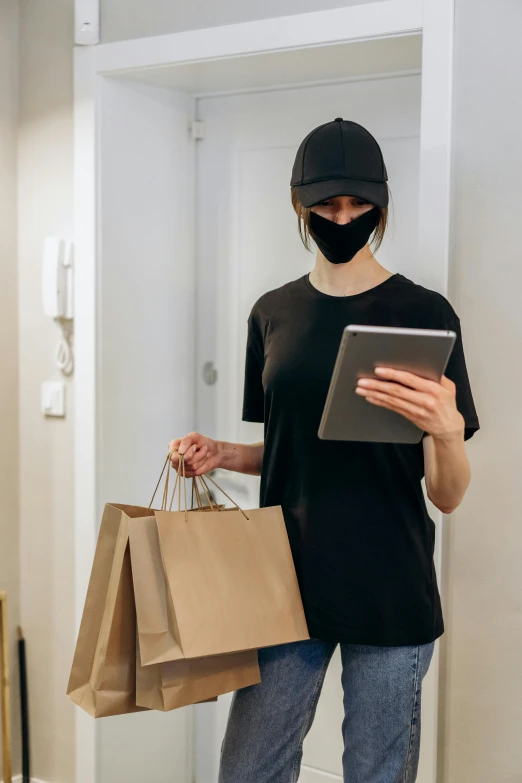a person wearing a face mask and holding shopping bags, renaissance, dark visor covering top of face, technologies, about to enter doorframe, holding a clipboard