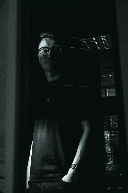 a man taking a picture of himself in a mirror, a black and white photo, unsplash, with haunted eyes and glasses, in the dark elevator, lachlan bailey, vhs effect