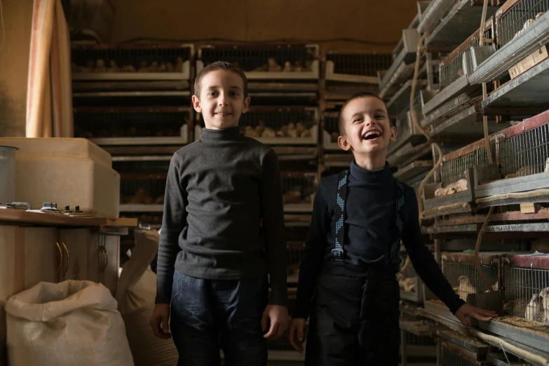 a couple of young boys standing next to each other, by Matthias Stom, pexels contest winner, bakery, nekro petros afshar, chickens, taking control while smiling