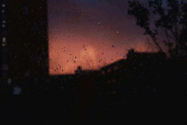 a view of a sunset through a rainy window, inspired by Elsa Bleda, pexels contest winner, raining! nighttime, the sky is a faint misty red hue, dark stormy night, while it's raining