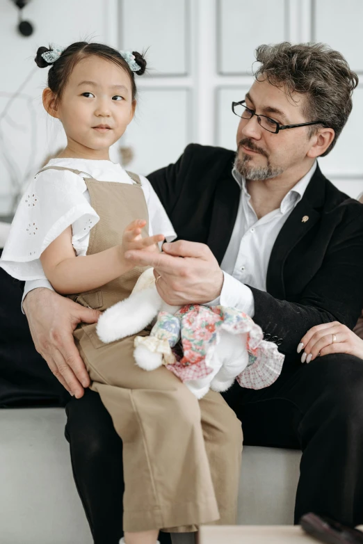 a man and a little girl sitting on a couch, pexels contest winner, japanese collection product, wearing business casual dress, delicate features, carefully crafted