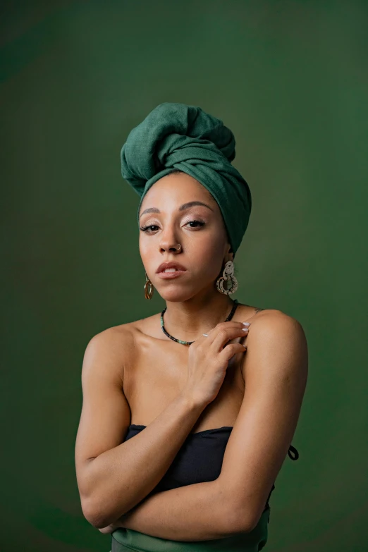 a woman in a green dress and a green turban, an album cover, by Stokely Webster, trending on pexels, renaissance, vanessa morgan, color portrait, oona chaplin, wrapped in a black scarf