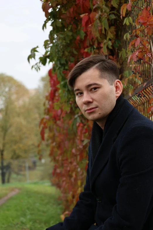 a man sitting on a bench in front of a fence, inspired by Andrei Ryabushkin, reddit, headshot profile picture, autum, asian male, russian academic