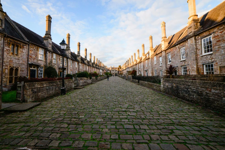 a cobblestone street lined with old buildings, by Gawen Hamilton, unsplash contest winner, mary anning, square, wide long view, terraced