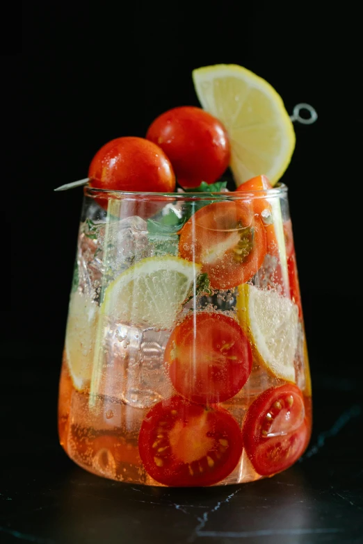 a glass filled with fruit and vegetables on top of a table, one tomato slice, crystal clear neon water, garnish, we go