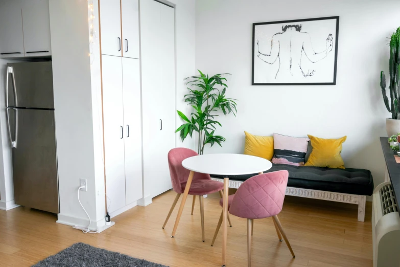 a living room filled with furniture and a white table, a minimalist painting, by Adam Marczyński, trending on unsplash, light and space, cubical meeting room office, small and cosy student bedroom, pink accents, ikea style