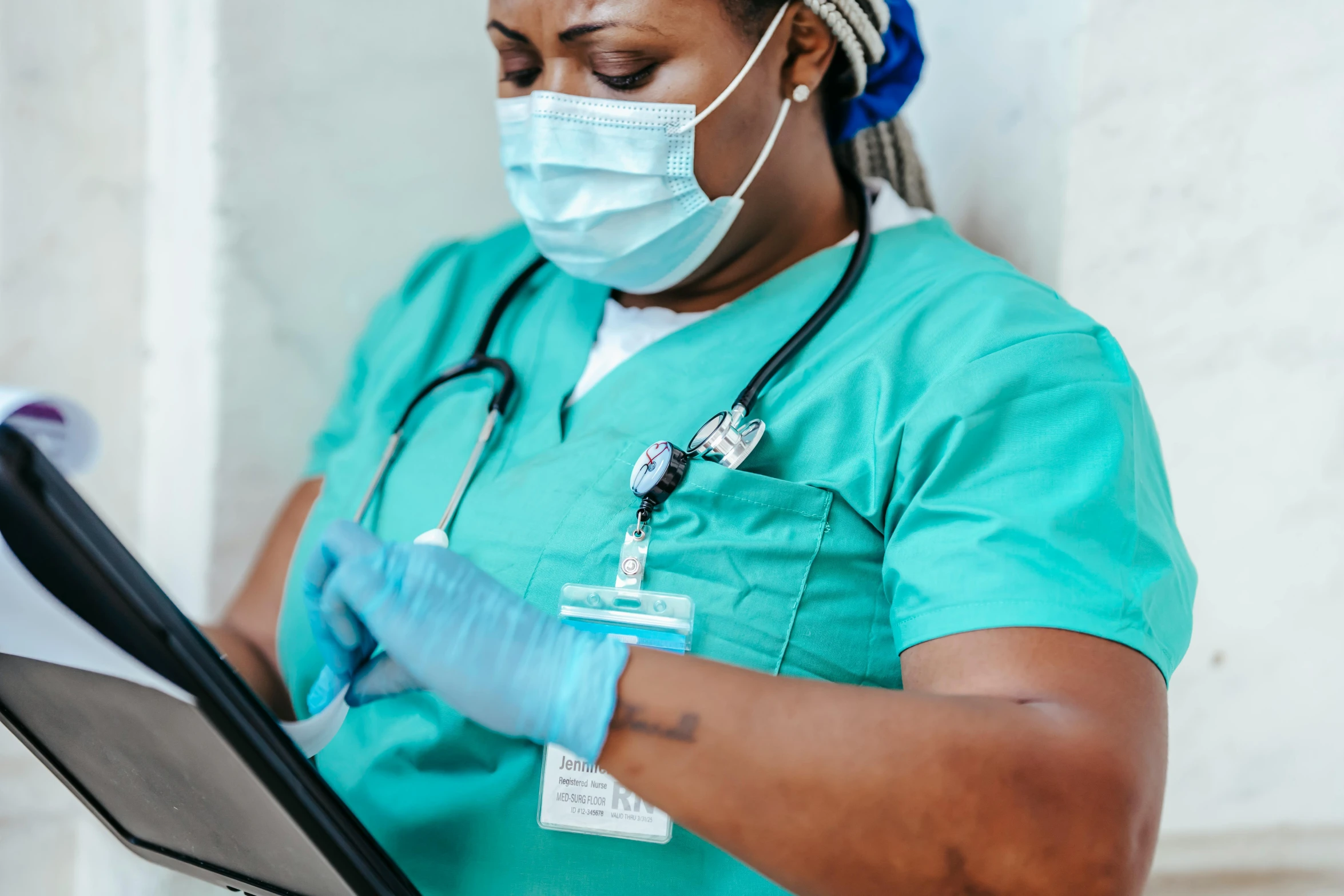 a woman in scrubs using a tablet computer, pexels, renaissance, black bandage on arms, diverse, masked person in corner, up-close