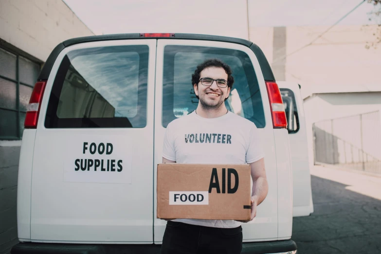 a man holding a cardboard box in front of a van, by Francis Helps, food, portrait image, pokimane, ash thorp khyzyl saleem
