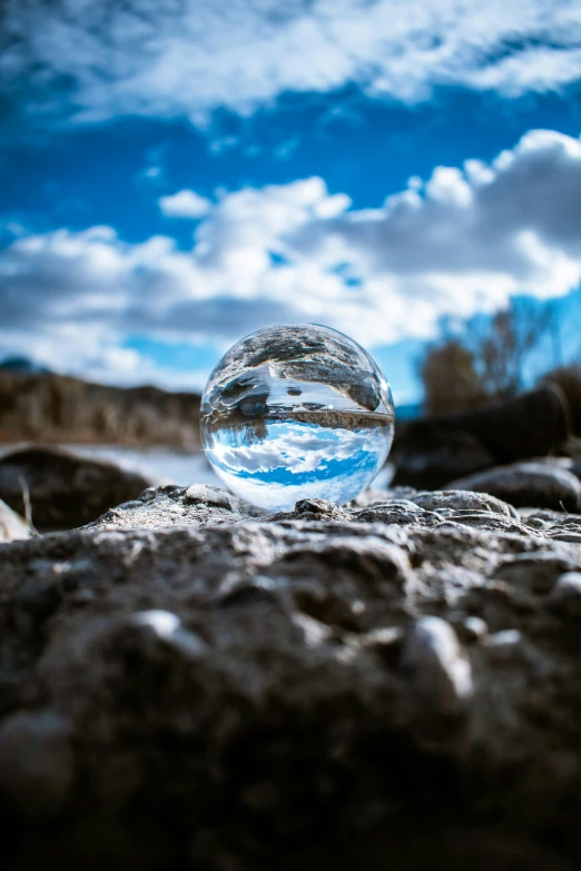 a glass ball sitting on top of a rock