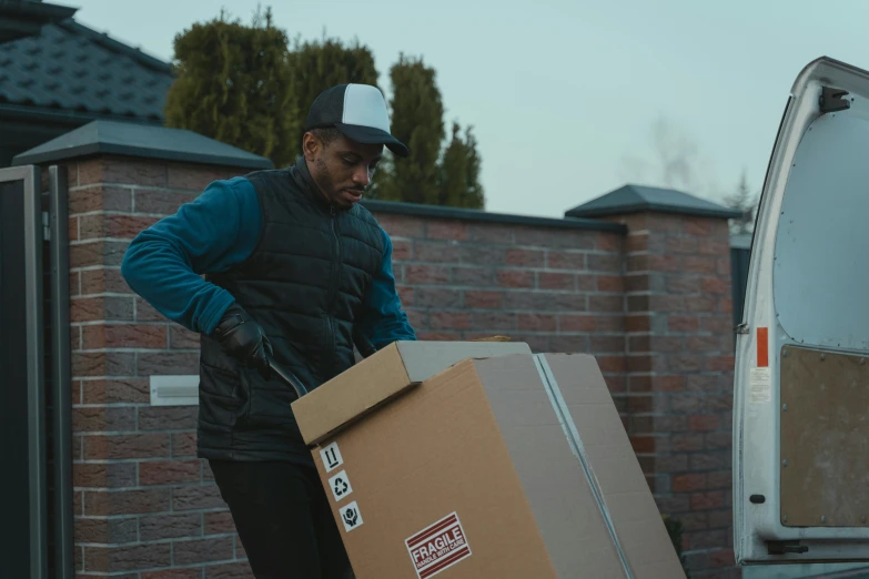 a man unloading a box from a moving truck, pexels contest winner, realism, black, riyahd cassiem, movie still 8 k, brown