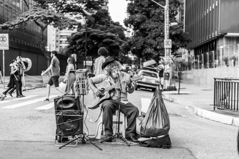 a black and white photo of a man playing a guitar, by Manuel Franquelo, pexels, street art, avenida paulista, old man doing with mask, hippie, square